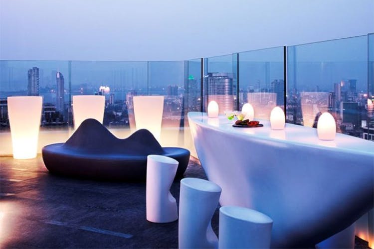 "Aer bar with chairs and lights in an outdoor seating.">