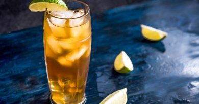 "dark and stormy cocktail with lemon and topping of ice">