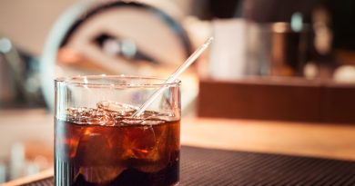 "Black russian cocktail with ice and a straw.">